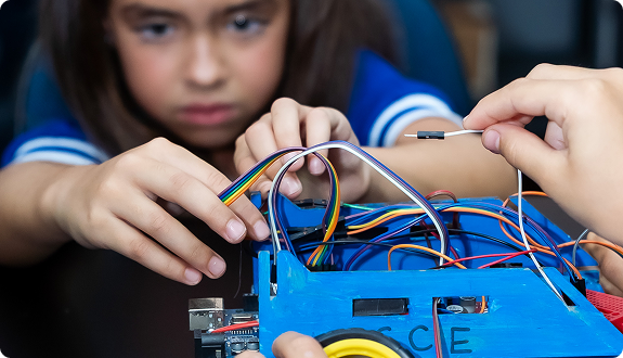 Aluna participando de atividade prática de robótica na Sala Maker